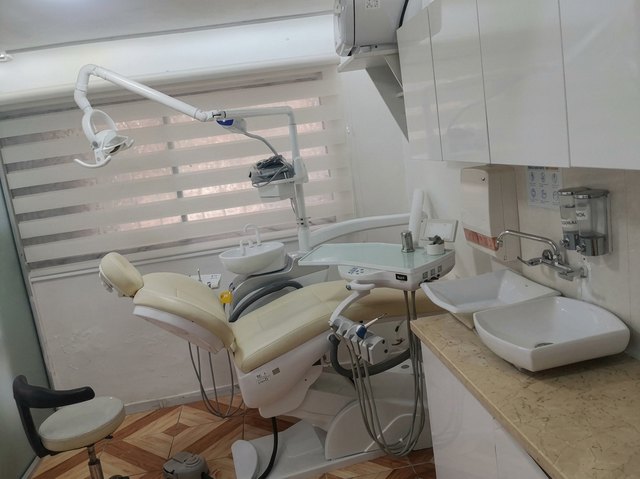 Consultorio odontológico con sillón crema y lavamanos